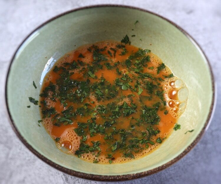 Oeufs battus avec du persil haché sur un bol