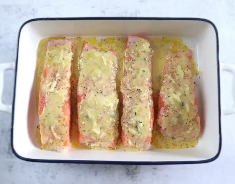 Assaisonner les filets de saumon avec une sauce au citron et à la moutarde sur un plat allant au four